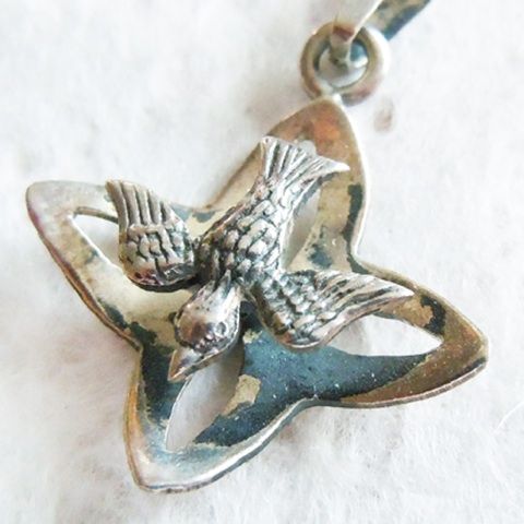   of this religious charm pendant it s the descending dove flying above